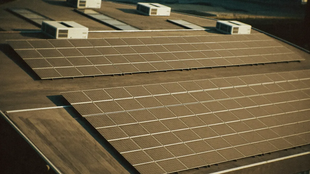 Pannelli fotovoltaici sul tetto di un capannone industriale alla luce dorata